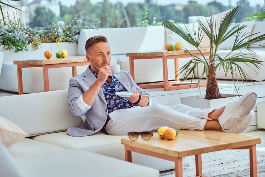 Successful man on a sofa drinking coffee