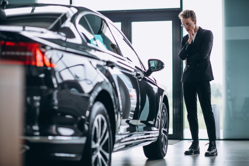 Man looking at a new car at dealership