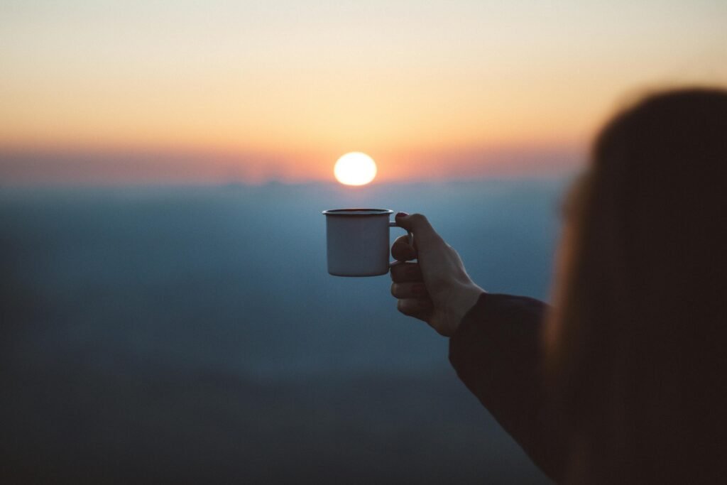 cup of coffee and sunrise in the background