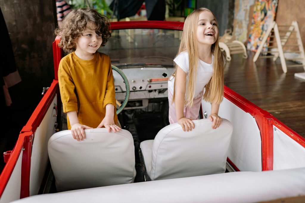 Two kids smiling in their toy boat