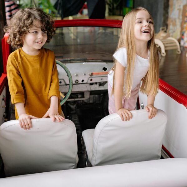 Two kids smiling in their toy boat
