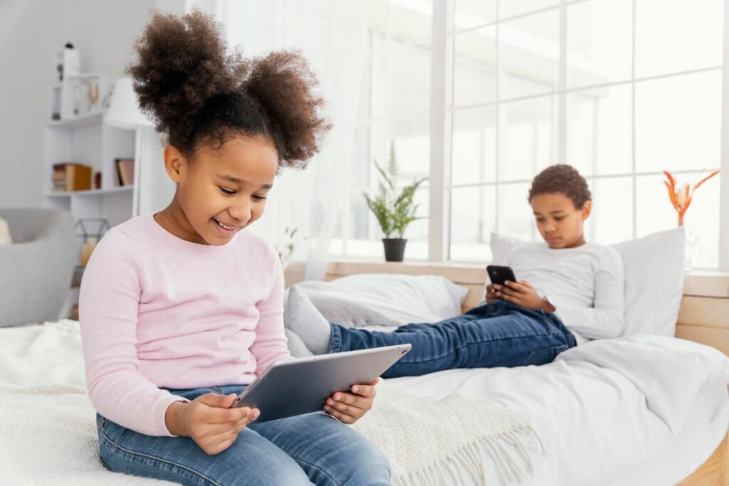 Boy and a girl playing on their digital devices