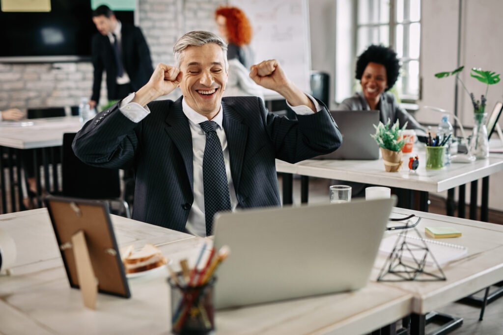 worker celebrating success while working on computer in the office.