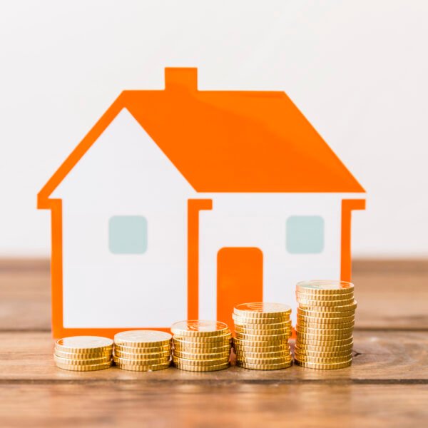 real estate wealth: close-up increasing stacked coins house model