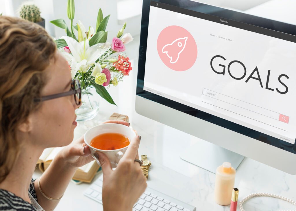 Woman looking on her computer monitor that says goal