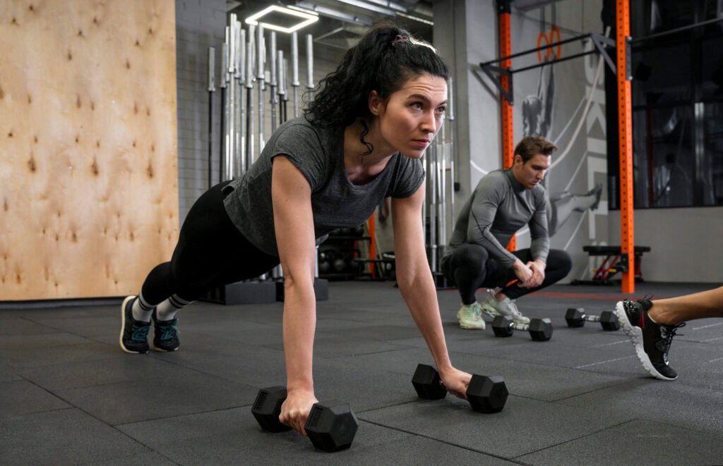 Woman working out indoors together with dumbbells