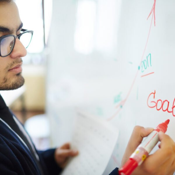 Man writing his goals on white board