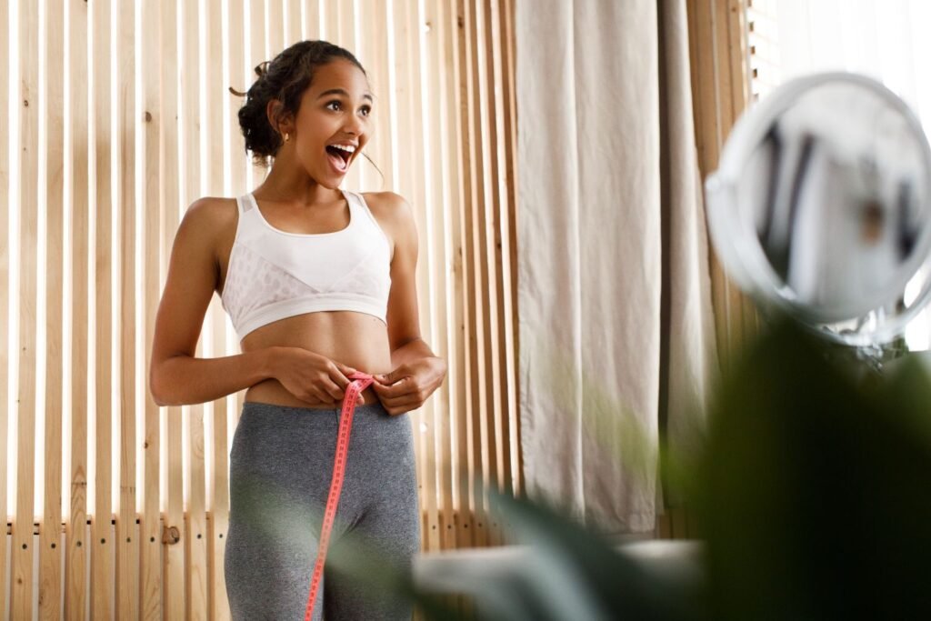woman is measuring her waist in her house