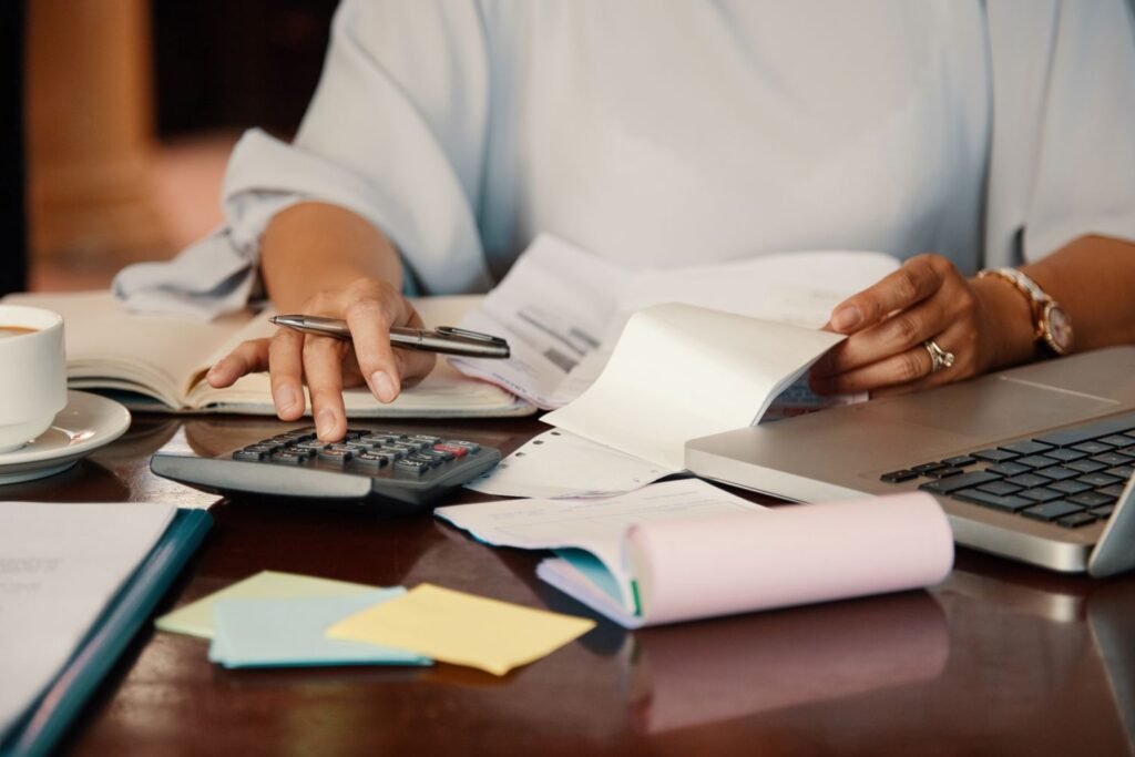 Mid-body of a person sitting at his desk and working on tax documents.