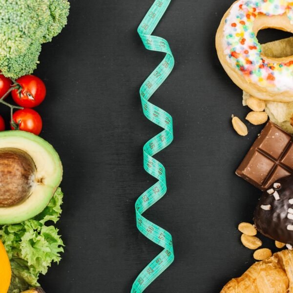 Image of healthy vegetables on one side versus unhealthy sweets on the other side divided by tape measure