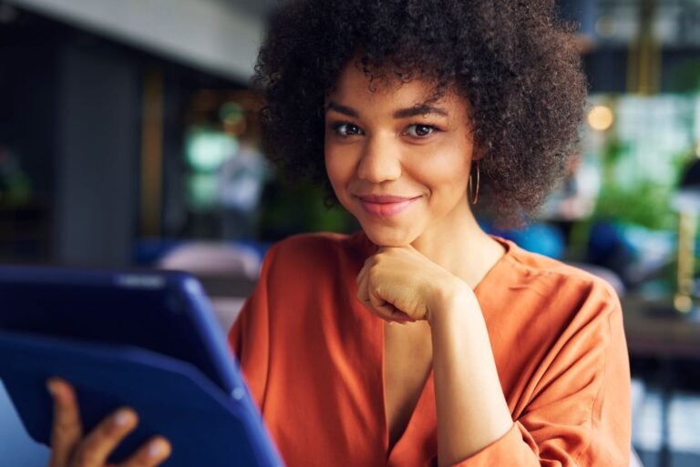 Young African businesswoman smiling while holding a tablet. Excited to grow her business with AI