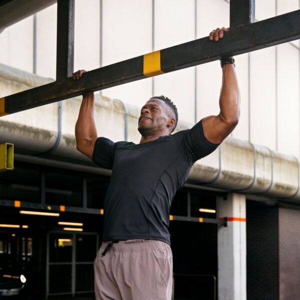 Fit man doing pull-ups outside