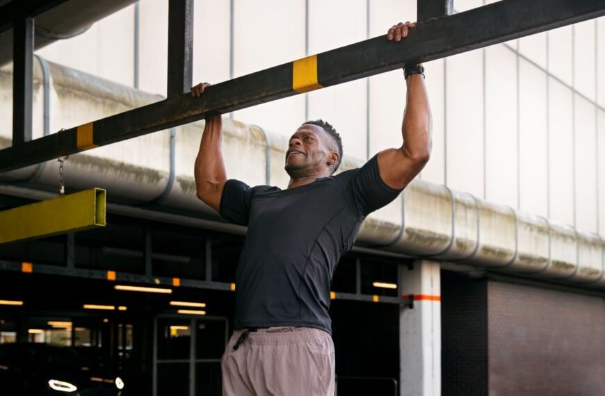 Fit man doing pull-ups outside