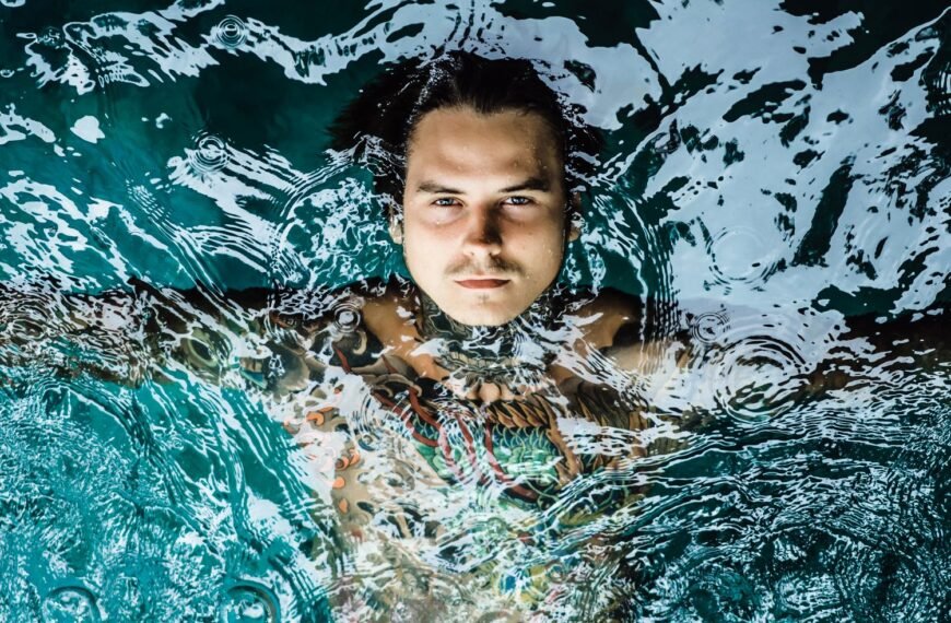 Young man submerged in cold water doing a cold plunge