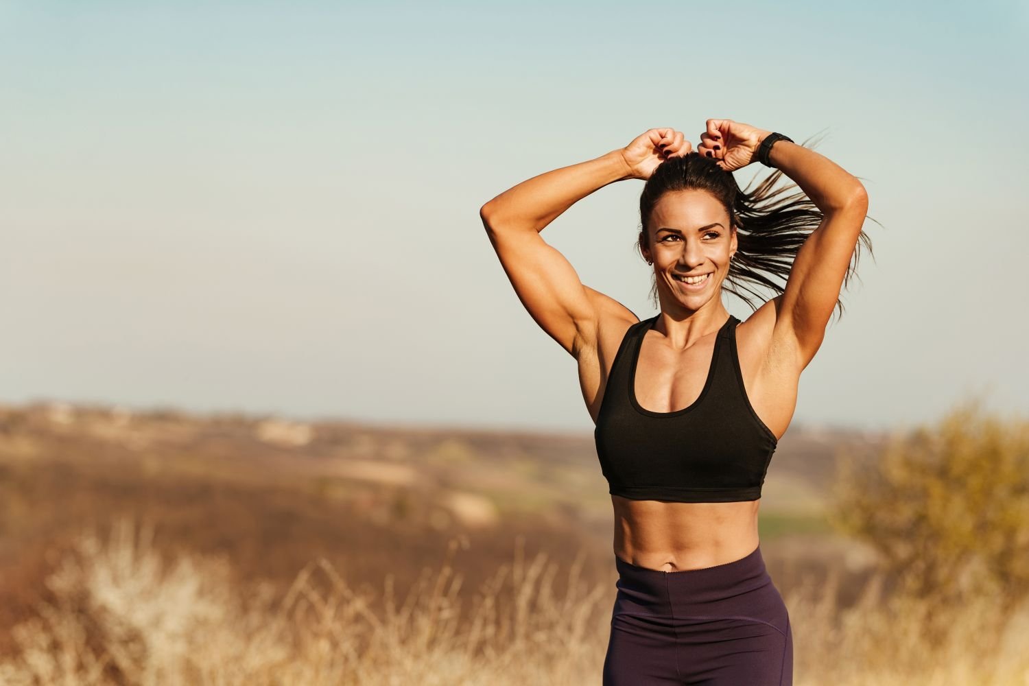 Happy fit woman outside preparing to run