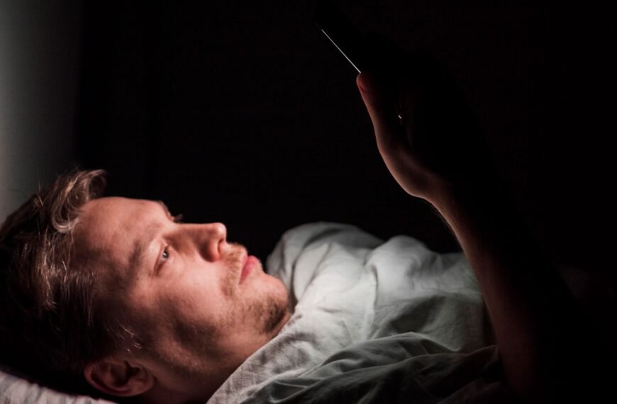 A man looking at a phone late at night with the glow illuminating their face — illustrating digital dopamine addiction and the need to fix dopamine levels