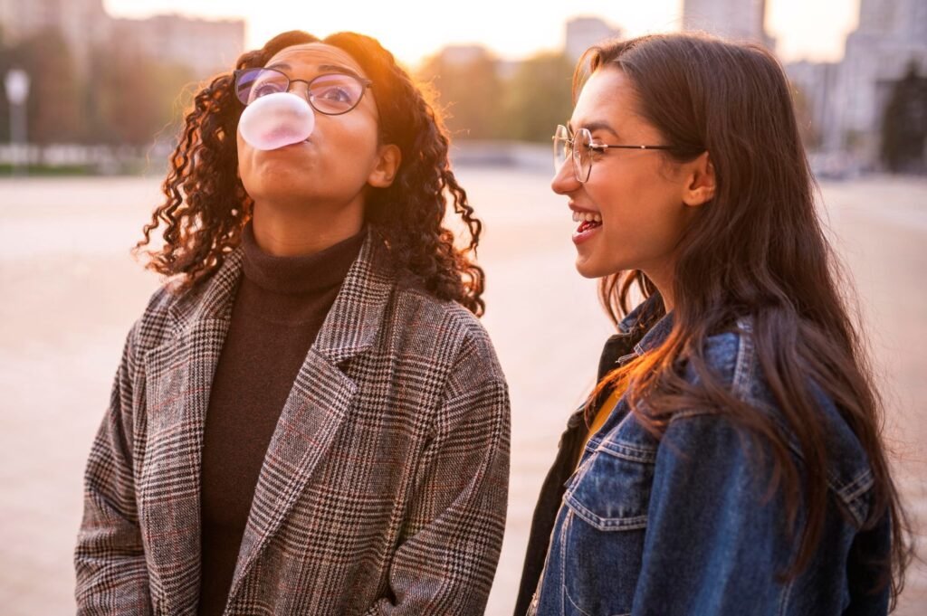 Two young women outside laughing together — illustrating what makes a good life according to Harvard's 86-year happiness study