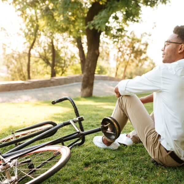 Person sitting peacefully outdoors looking content, symbolizing the happiness formula